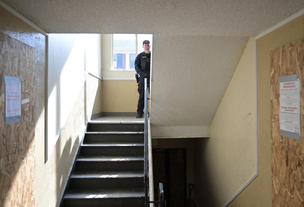 Police officer stands in stairway in apartment building