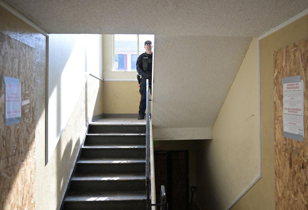 Police officer stands in stairway in apartment building