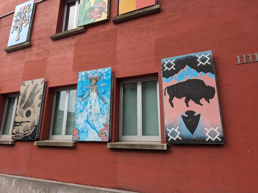 red-orange building with paintings on the outside, in rows