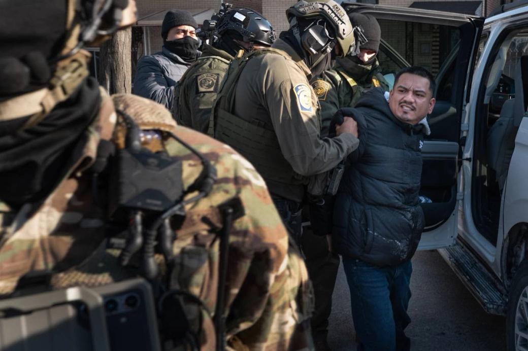 Man put into police vehicle by multiple U.S. Customs and Border Patrol agents