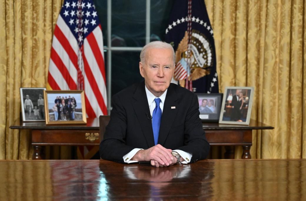 President Joe Biden sits behind his desk in the Oval Office.