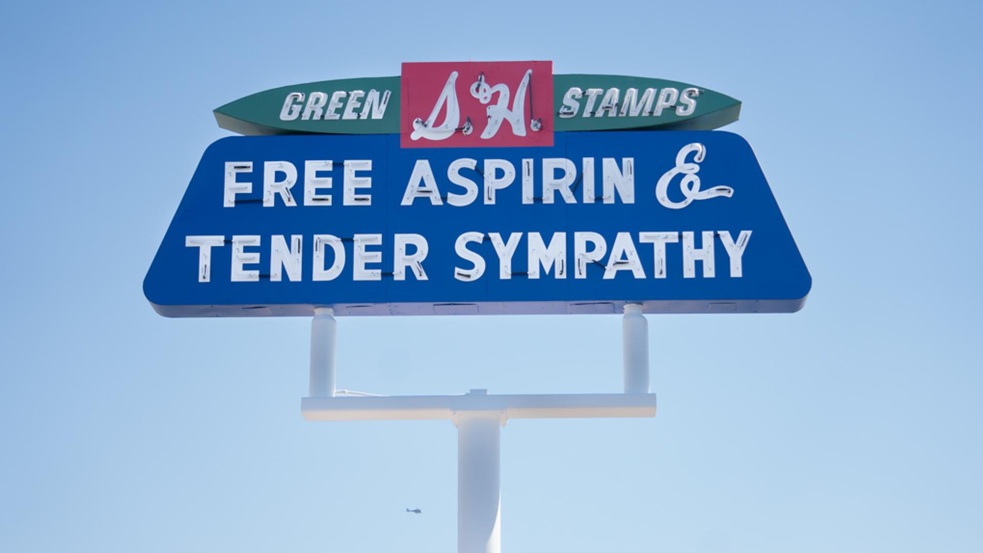A sign that says "Free Aspirin and Tender Sympathy."