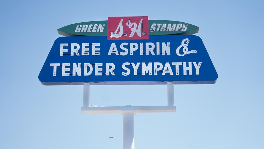 A sign that says "Free Aspirin and Tender Sympathy."