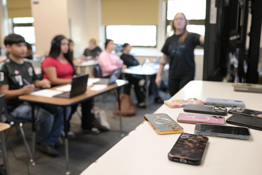  Smart phones rest on a desk away from the students who brought them into the classroom at Morey Middle School in Denver. 