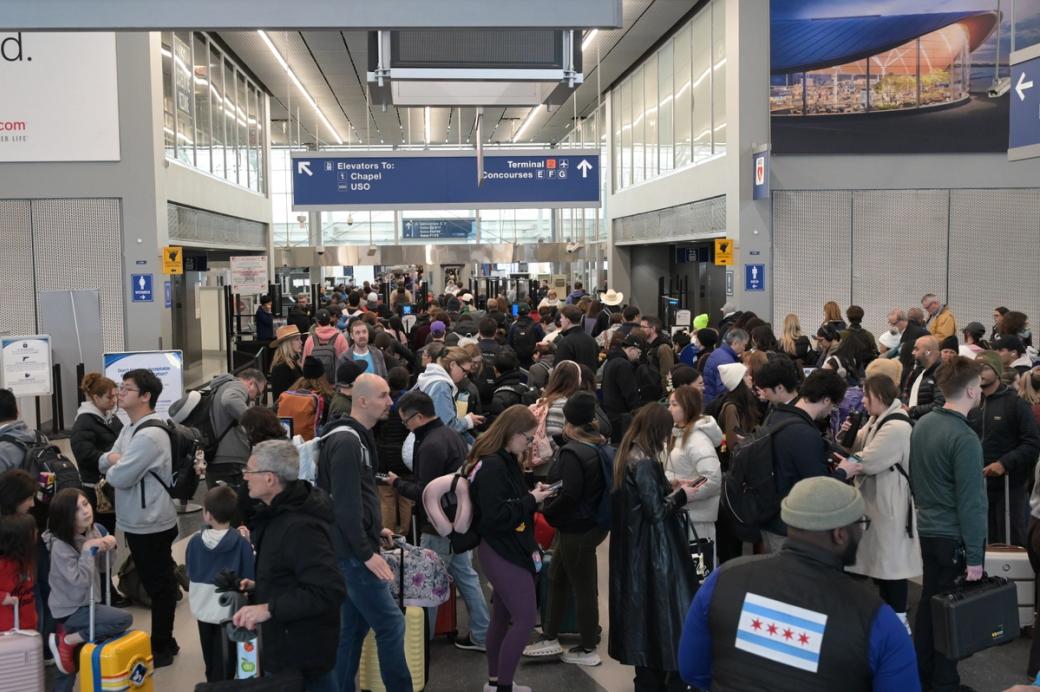A large crowd of people waiting in a TSA line at O'Hare