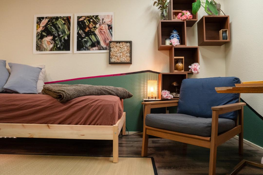 room with a day bed and a chair and art on the walls
