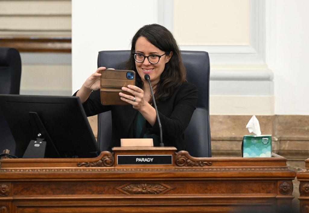 Former Denver City Council member Sarah Parady takes a photo of her family, while she sits at her seat in the City Council chambers