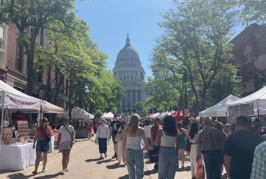 People walk along State Street by the Wisconsin Capitol.