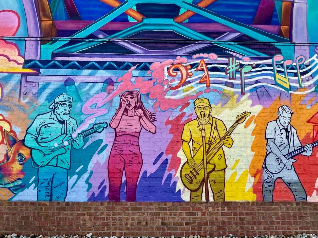 a colorful mural of people playing music and singing