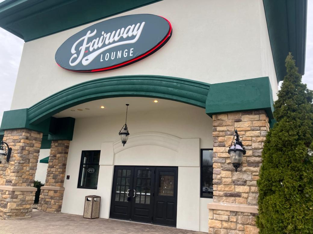 The entryway to a restaurant with stone columns flanking the entryway.