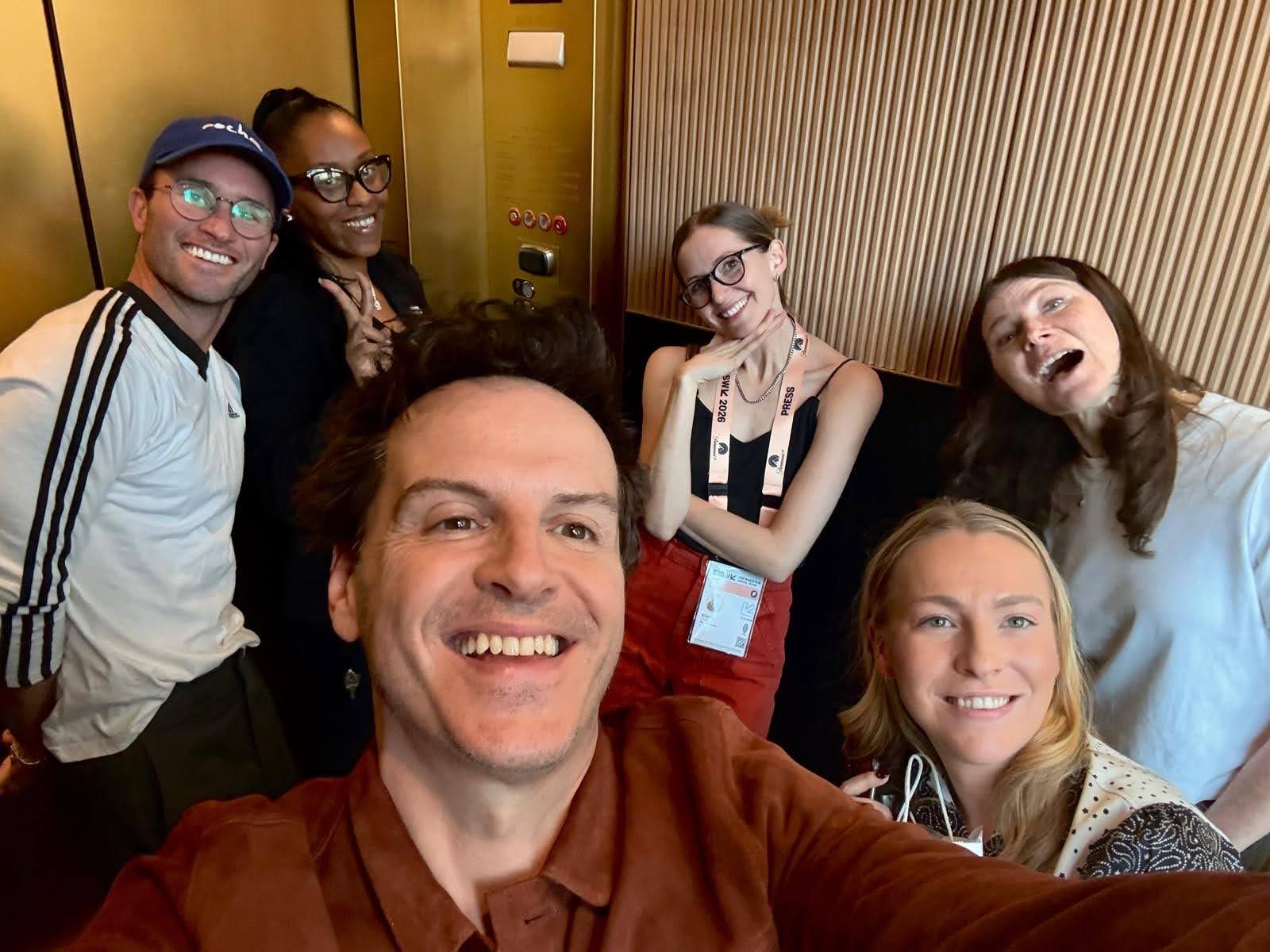 Actor Andrew Scott posing for a selfie with five other people.