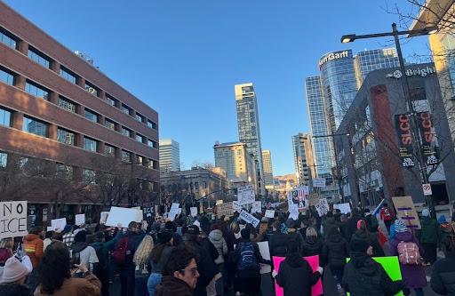 People holding signs walking down the streets of downtown Salt Lake City.