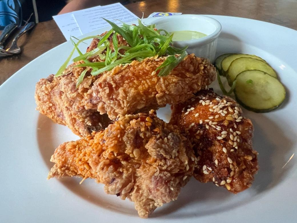 Crispy wings with sesame seeds, served with pickles and green garlic ranch.