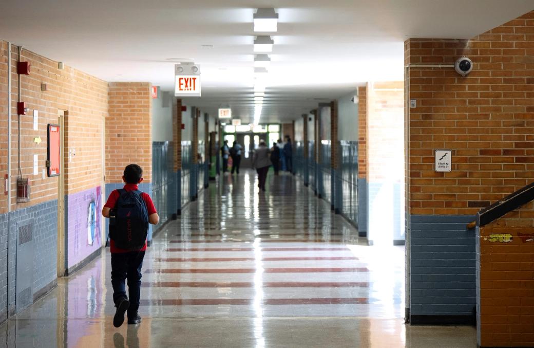 A high school hallway with one child walking down the hall