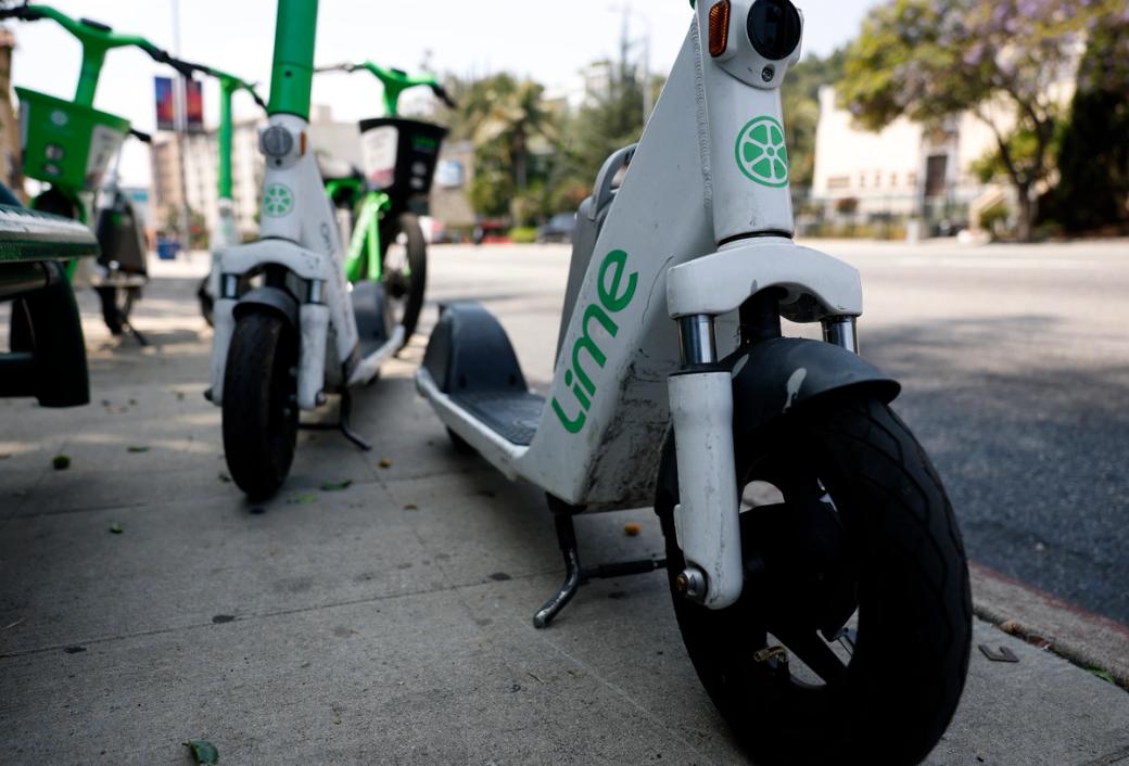 Close-up ground level view of motorized rental scooters on sidewalk
