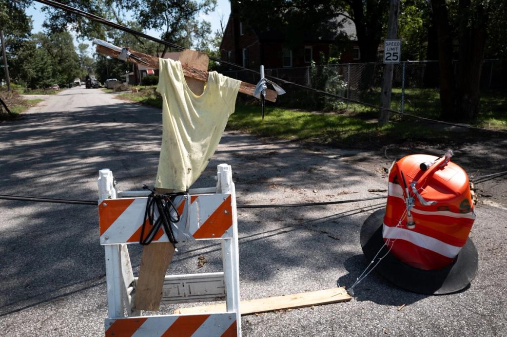 A piece of wood with a shirt on it tied to a road block