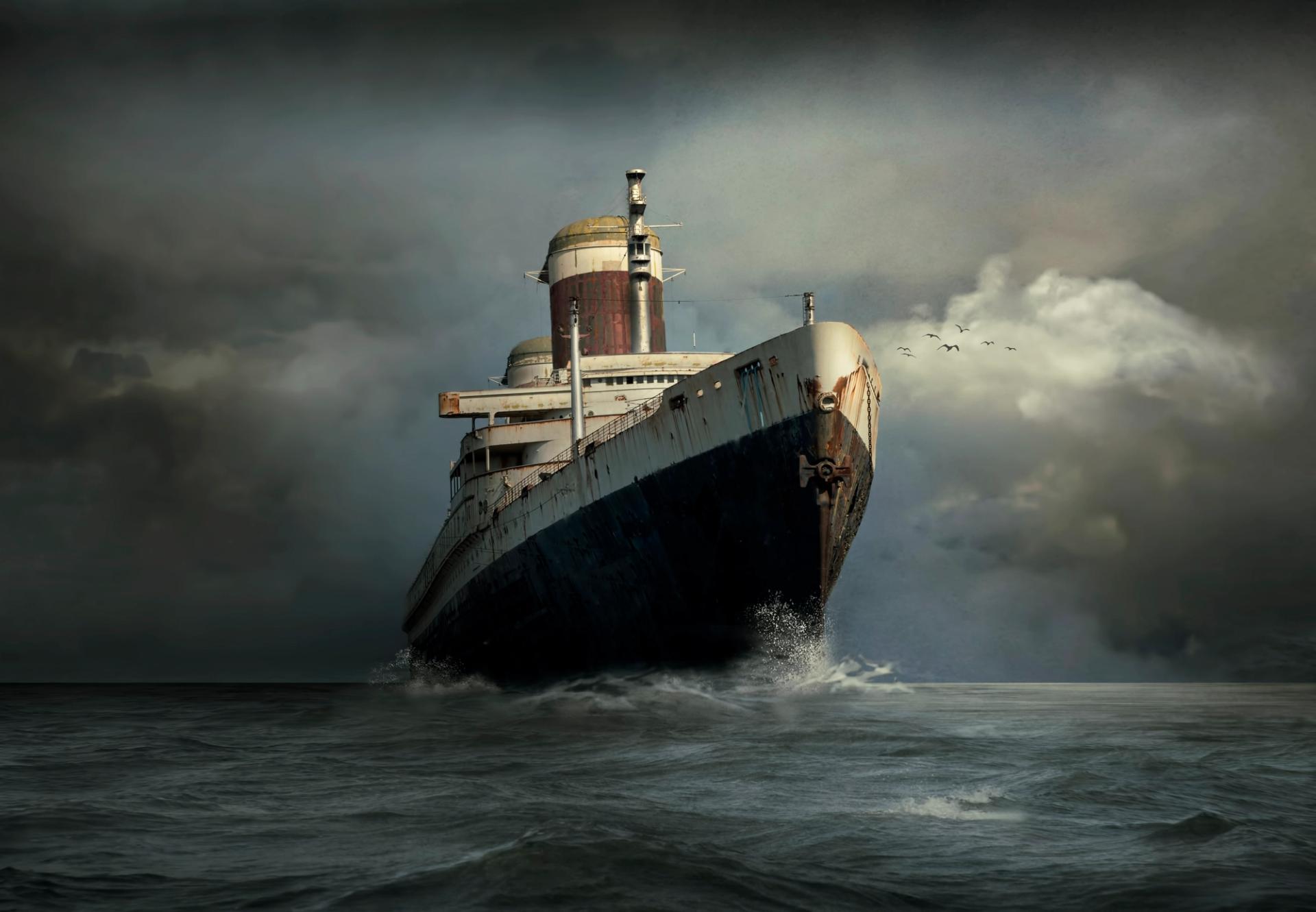 A ship sailing through the ocean on a cloudy, dark day.