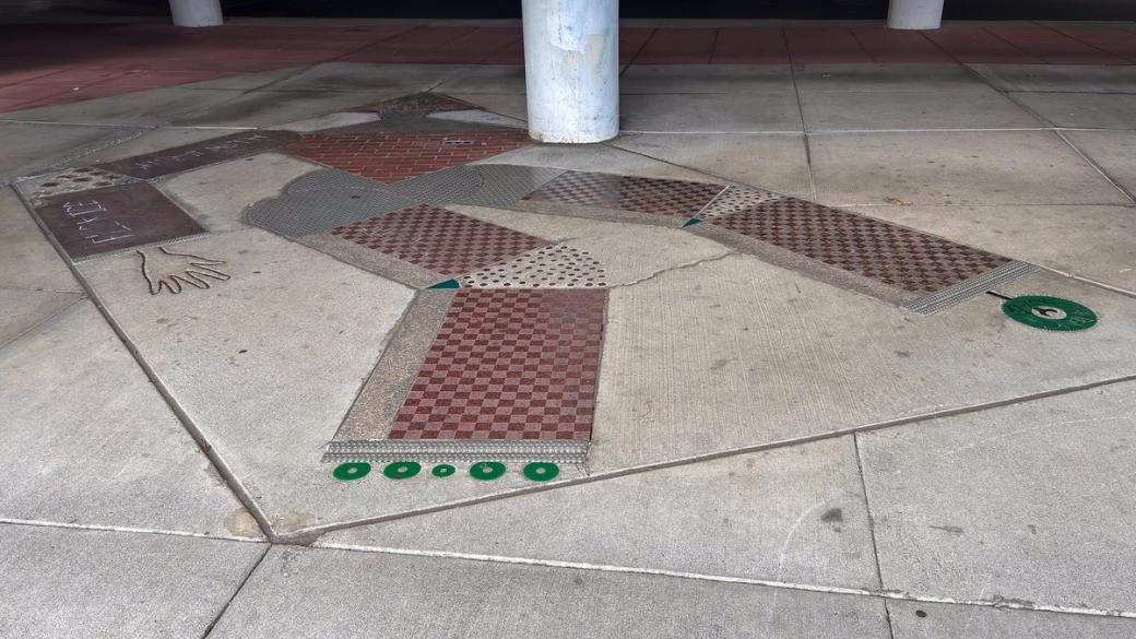 Light and dark red checkerboard design on concrete.