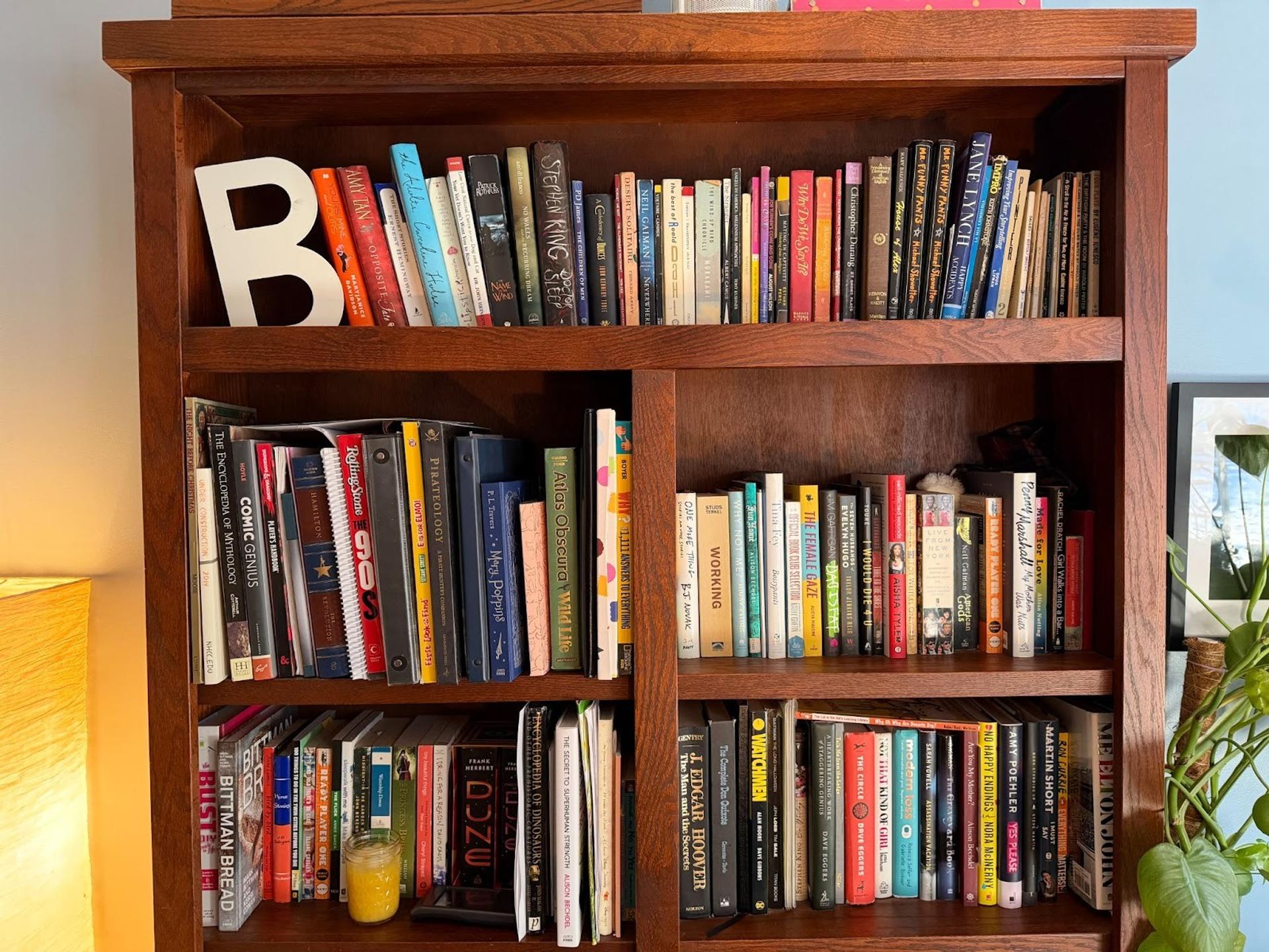 A bookshelf filled with books. There is a letter "B" on the top left