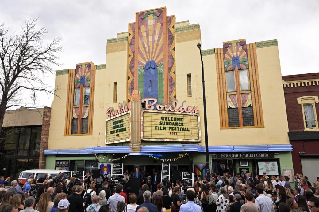A crowd assembles out front of the Boulder Theater, whose marquee reads” Welcome Sundance Film Festival 2027.”