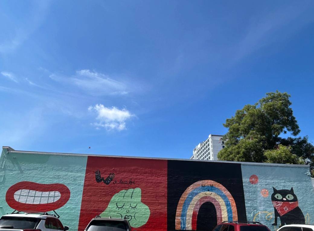 A colorful mural that includes a black cat.