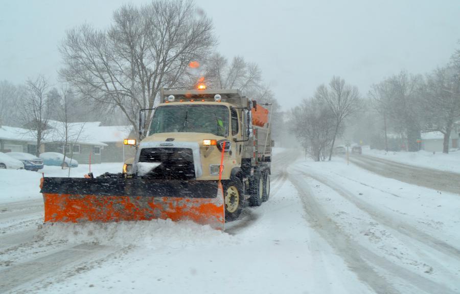 snow plow comes down the street