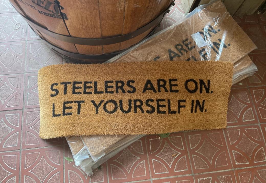 Welcome mat at Armful of Flowers in Mt. Washington. Reads, "Steelers are on. Let yourself in."