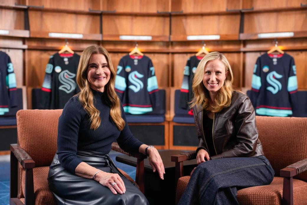 Melinda French Gates sits next to Samantha Holloway in the Kraken’s locker room in Climate Pledge Arena.