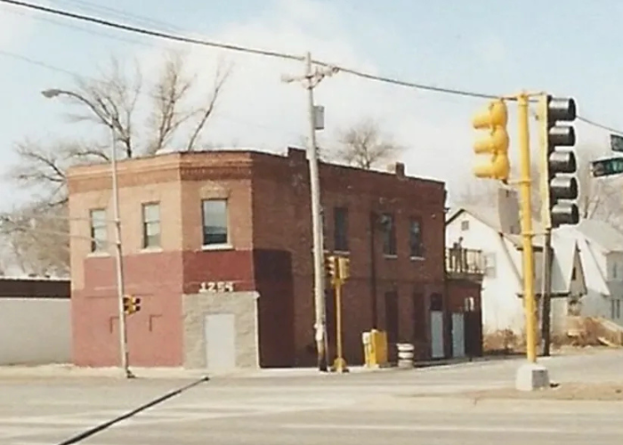 A two-story red brick building on a street.