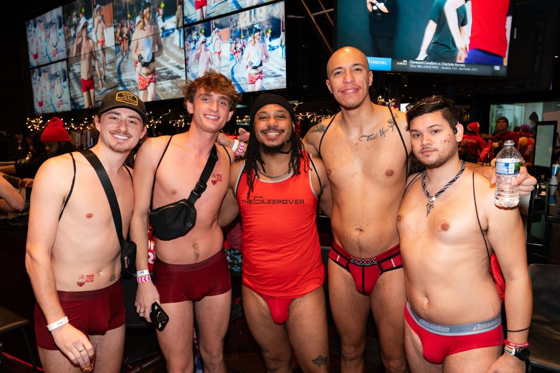 A group of men in their underwear in a bar