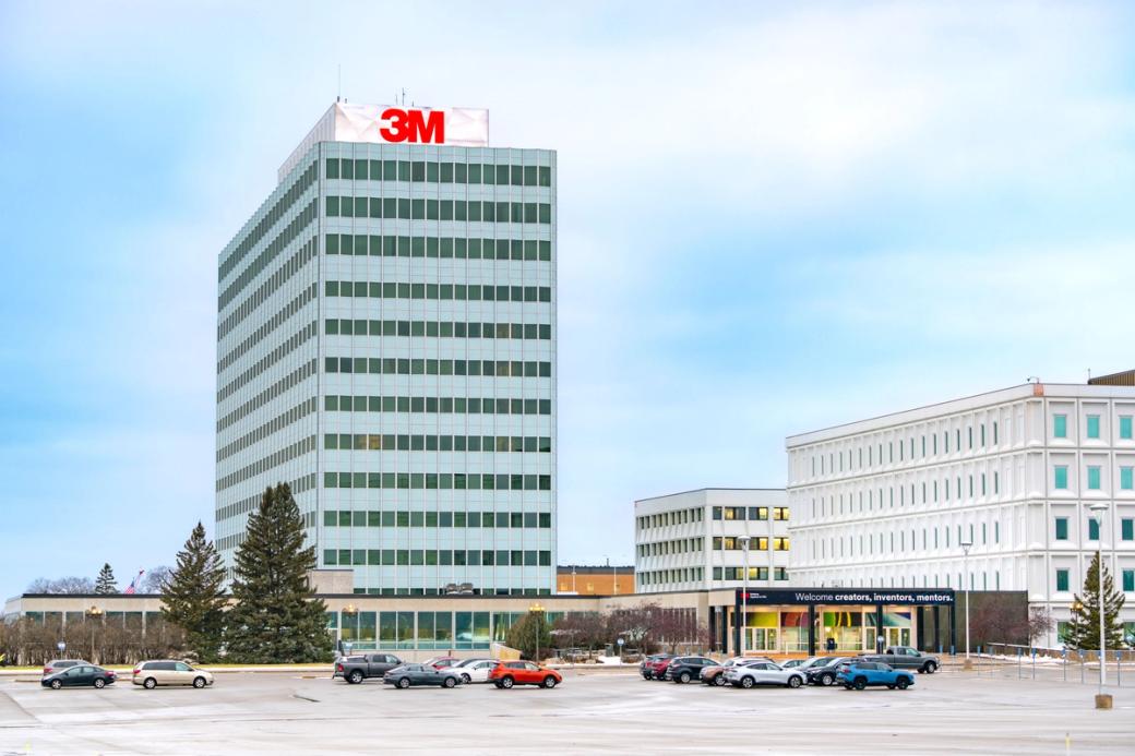 Exterior ground level view of large commercial buildings, with large parking lot in foreground