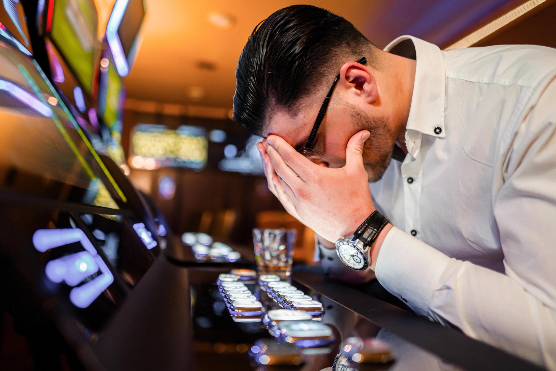 Photo of man feeling remorse at slot machines