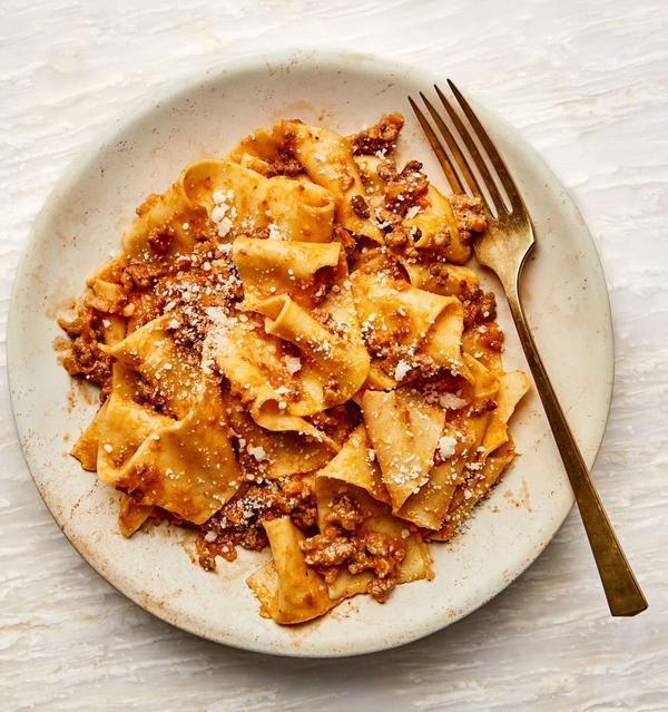 Pappardelle with Ragú Bolognese on a plate with a brass fork