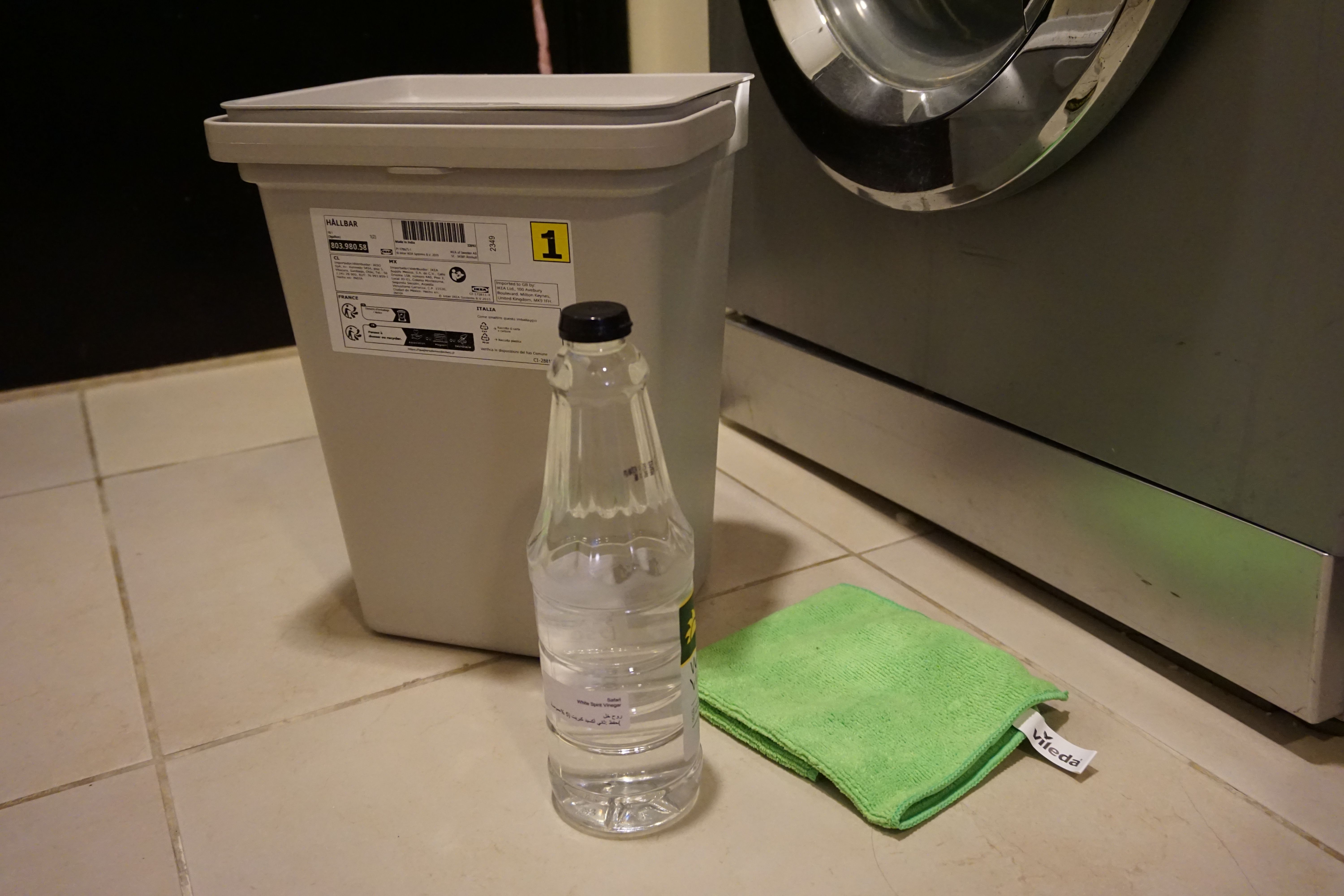 bildet viser eddik, en bøtte og klut, rens av vaskemaskin