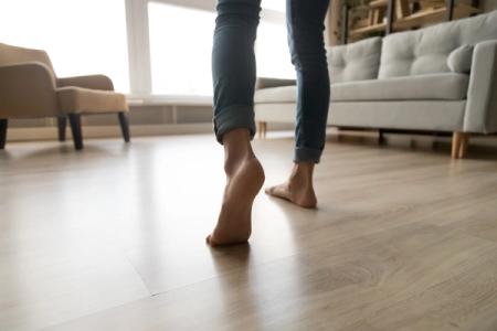 et bilde av en person som går på parkettgulv, vannbåren varme