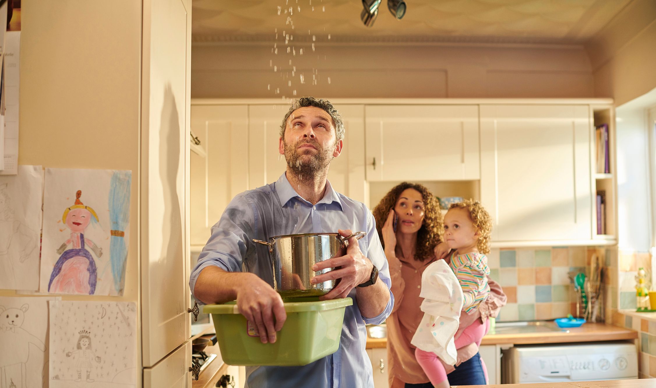 et bilde av en familie som ser på en taklekkasje, vannskade