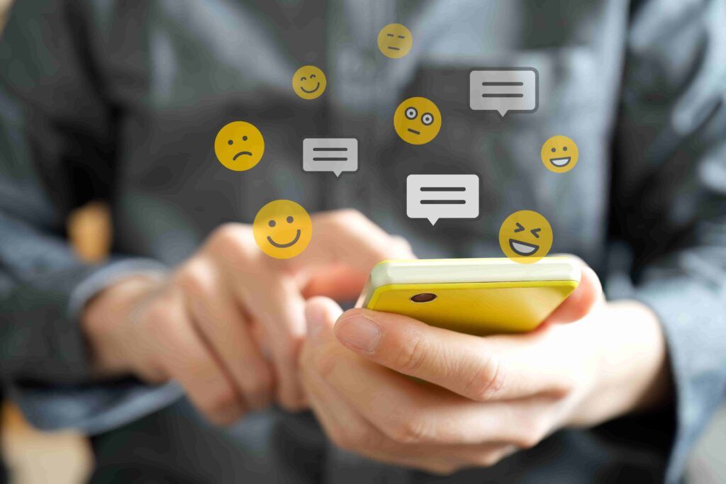 A person holding a smartphone and Emojis