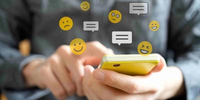 A person holding a smartphone and Emojis