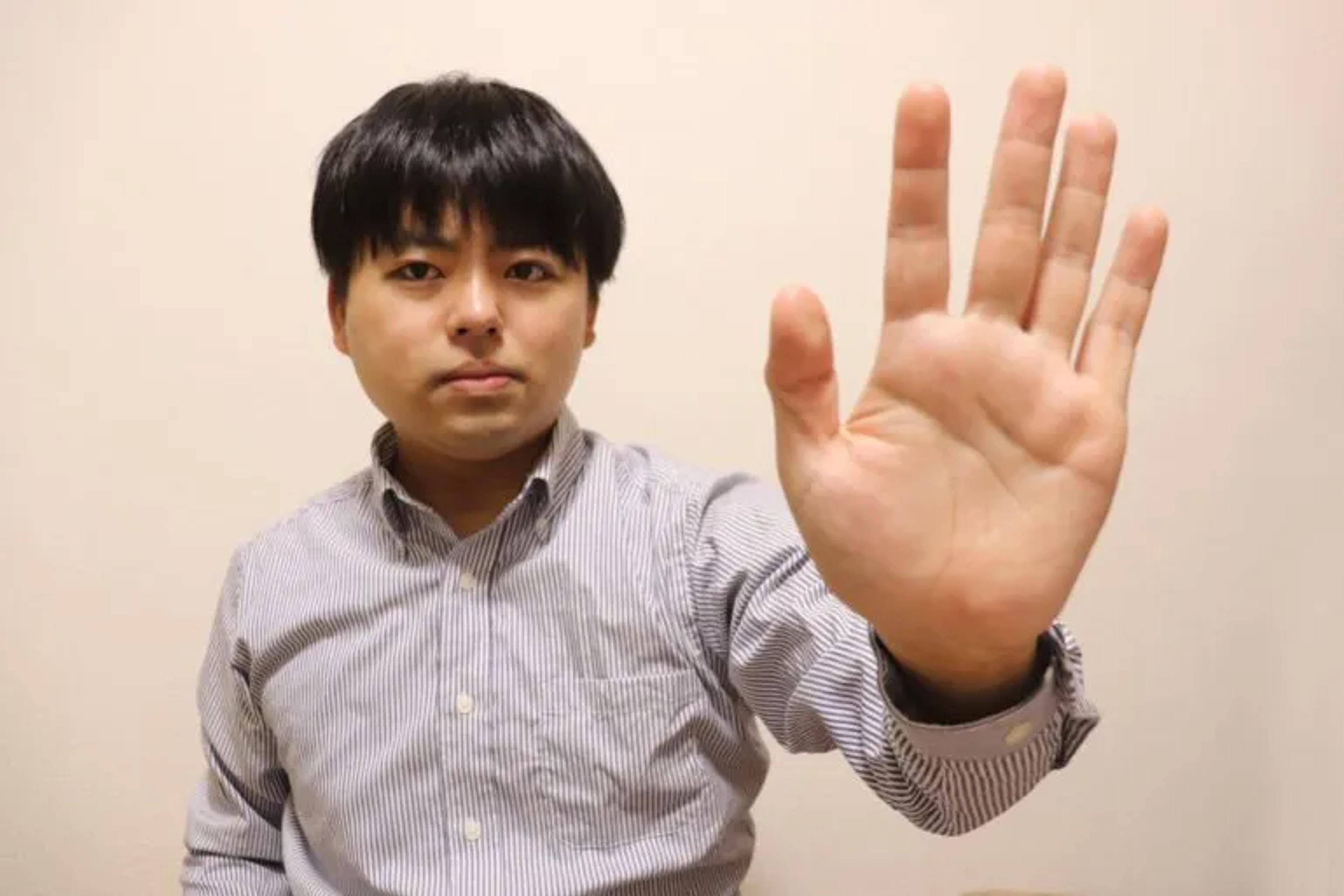 Man putting out open hand to say stop