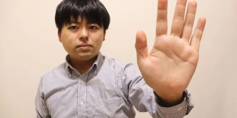 Man putting out open hand to say stop