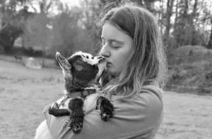 A picture of a girl holding a cuddly baby goat