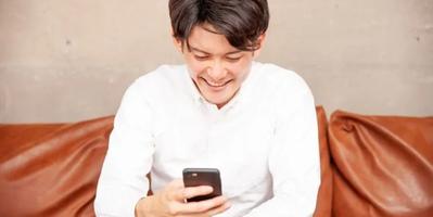 Man smiling while looking at his Smart phone