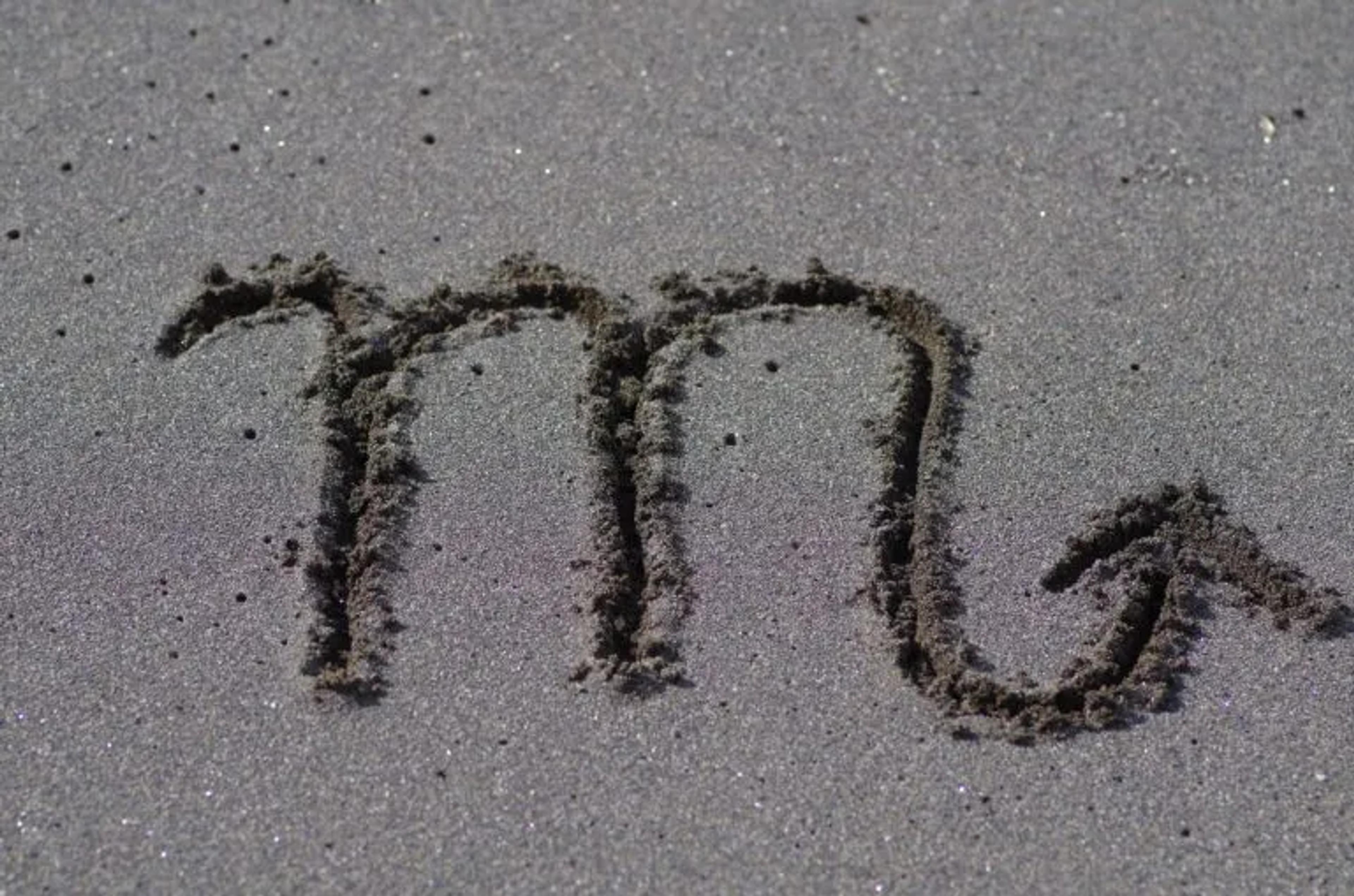 Image of the Scorpio sign writen in sand