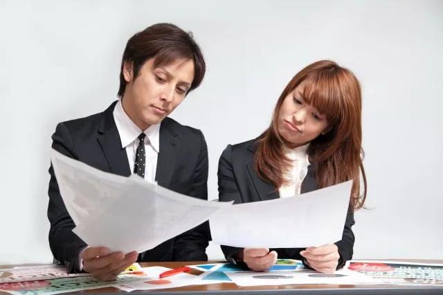 two people looking at two papers