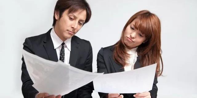 two people looking at two papers