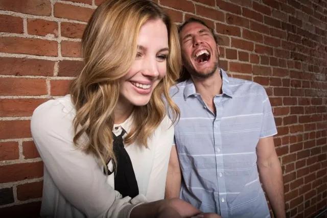 people laughing in front of a computer