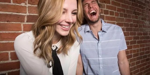 people laughing in front of a computer