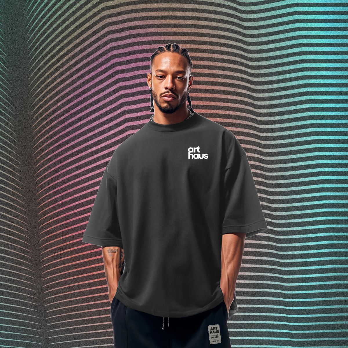 Model wearing an oversized black Art Haus T-shirt against a multicolor graphic field.