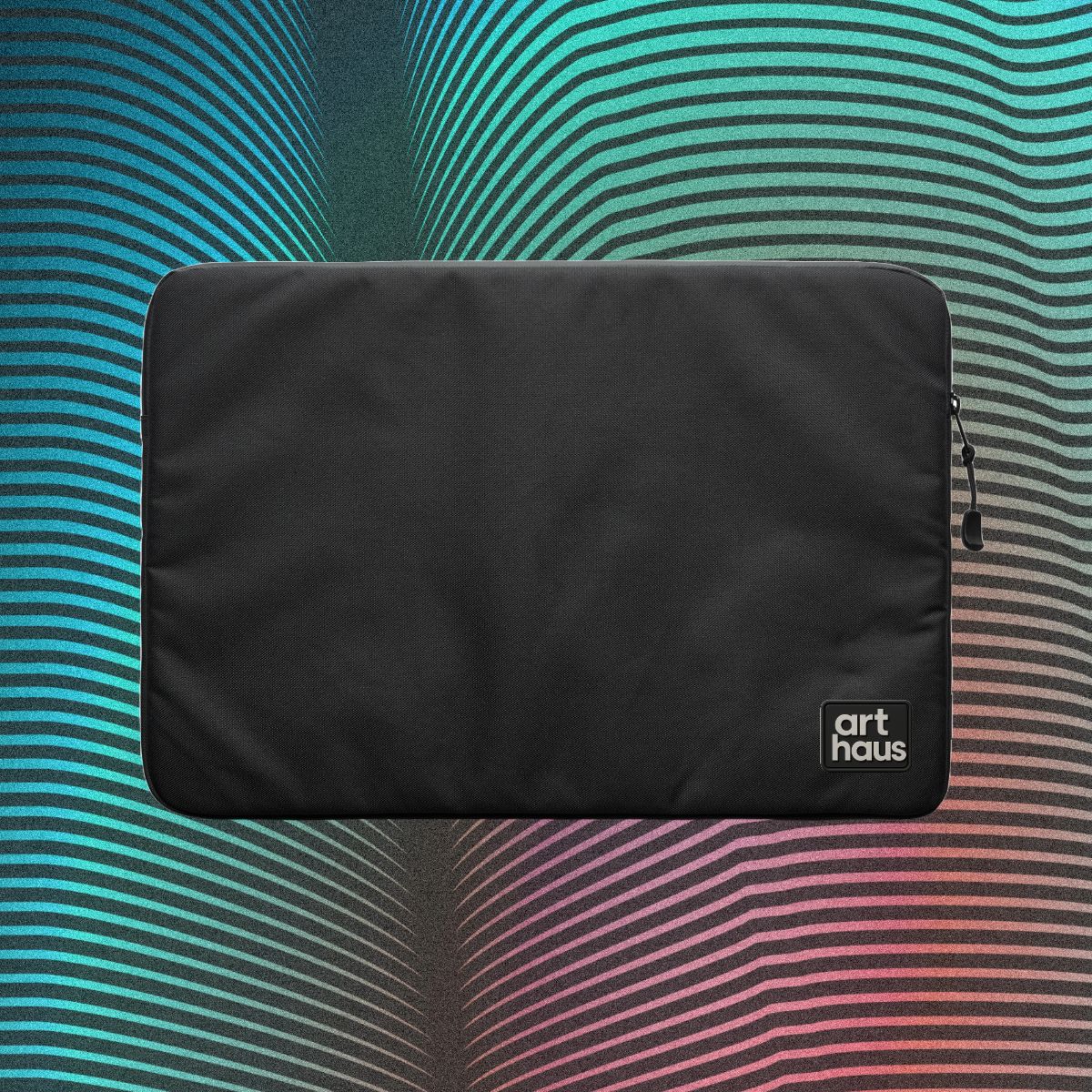 Black Art Haus laptop sleeve with a dimensional wordmark patch on a multicolor graphic backdrop.