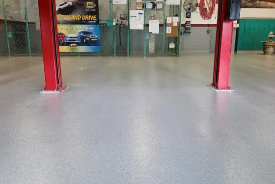 Technical school automotive bays in Miami after installation: finished quartz floor under the vehicle lifts